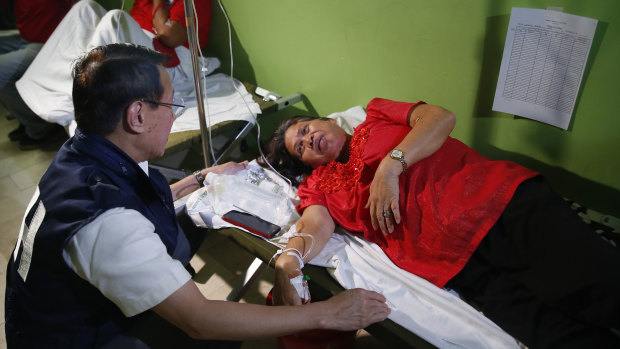 Philippine Health Secretary Francisco Duque III talks to patients who fell ill during the 90th birthday celebration.