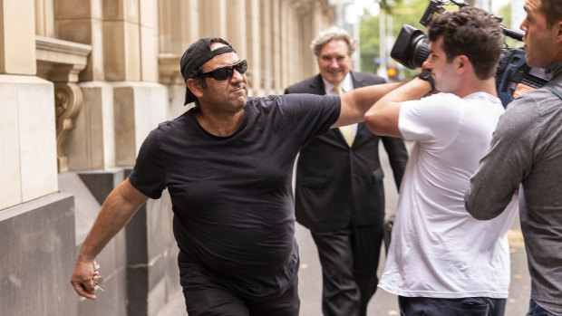 A man believed to be the son of Domenico Natale is seen pushing a cameraman after leaving the Supreme Court of Victoria on Tuesday.