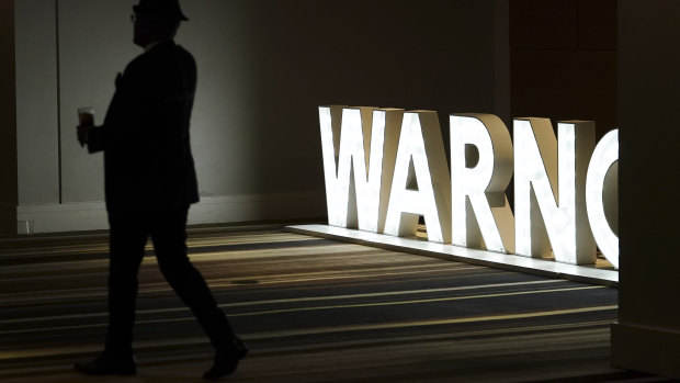 A person walks near a sign during an election night watch party for Democratic Senator Raphael Warnock.