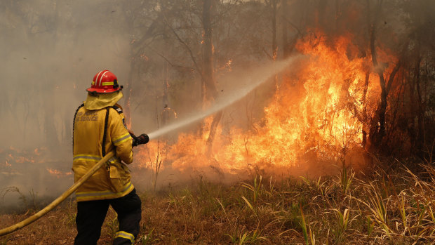 A firefighter works to contain a blaze in Old Bar, on the NSW Mid North Coast, last  weekend.   