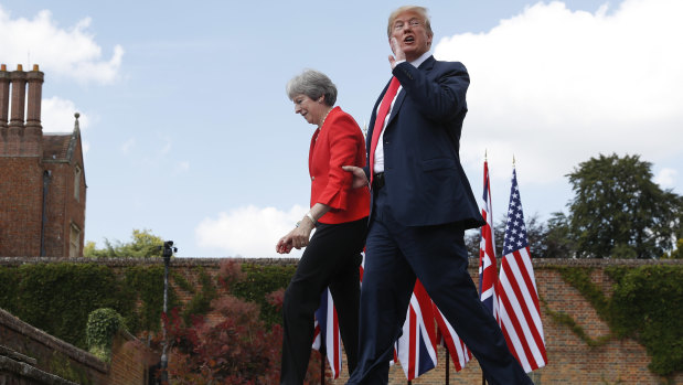President Donald Trump responds to a reporter's shouted questions as he walks with British Prime Minister Theresa May at the conclusion of their joint news conference at Chequers.