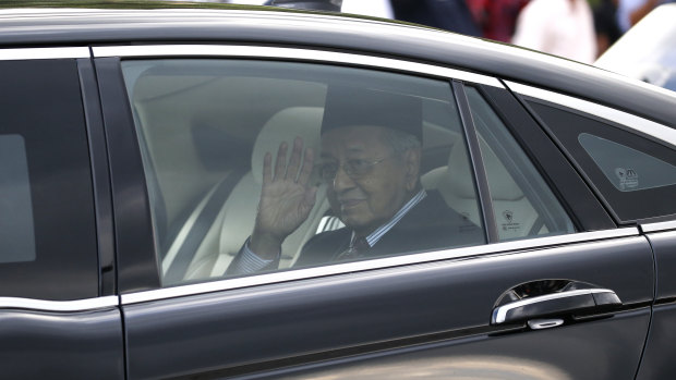 Mahathir Mohamad waves after being granted an audience with the Malaysia's King Sultan Abdullah Sultan Ahmad Shah at the National Palace in Kuala Lumpur.