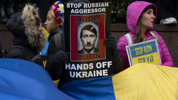 Supporters of Ukrainian sovereignty protest the Russian invasion with banners likening President Putin to Hitler.. 