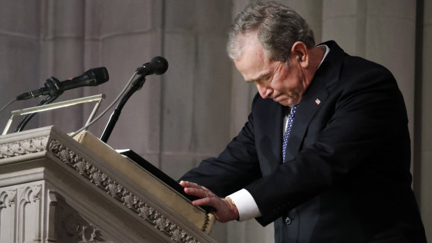 Former US president George W. Bush pauses while speaking.