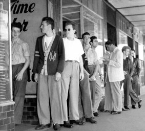 Bodgies lining up for haircuts. Hardly the most threatening sight.