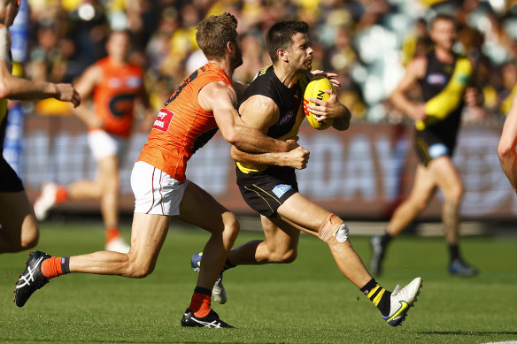Former skipper Trent Cotchin looks to burst clear of a tackle from Callan Ward in round two.