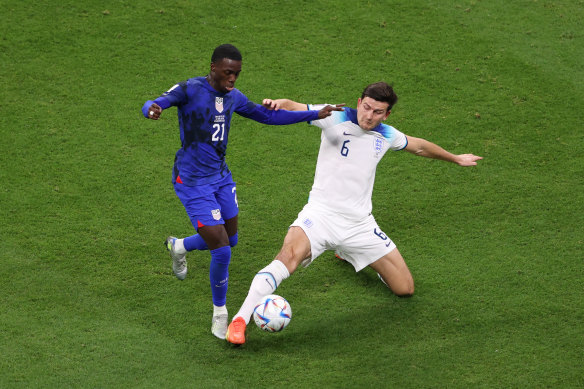 Timothy Weah of United States battles for possession with Harry Maguire of England.