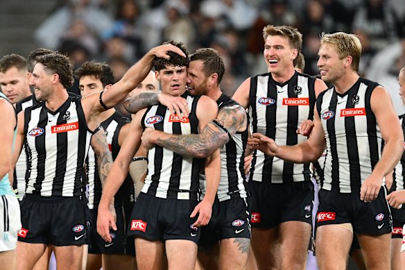 Collingwood players congratulate Sam Swadling after he kicks a goal on debut.