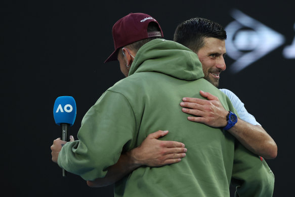 Nick Kyrgios and Novak Djokovic embrace after the Serb won his quarter-final against Taylor Fritz at the Australian Open.