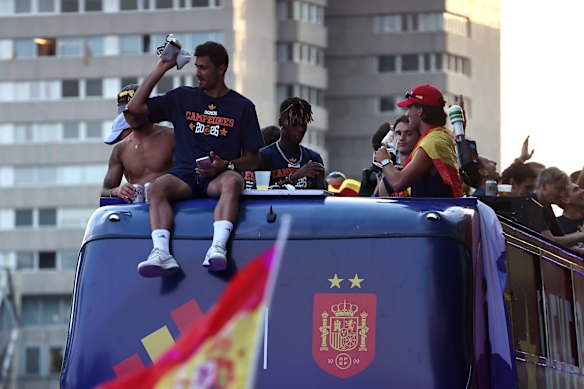 Spain captain Rodri sits atop the bus carrying the winning World Cup players through the streets of Madrid.