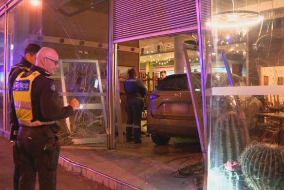 Police at the scene where a car crashed into the former Franco Cozzo store.