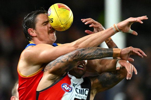 Joe Daniher of the Lions is hit in the face by the ball as he goes for a mark against Bradley Hill.