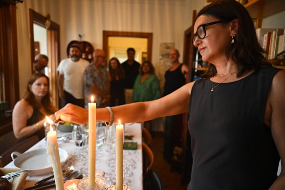 Rochelle Abood con amigos en Coogee enciende velas a las 6:45 p. m. en honor de las personas muertas y heridas exactamente una semana antes en el ataque terrorista en Bondi Beach.