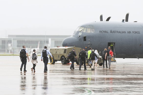 Australian Federal Police personnel board an RAAF C-130 Hercules  bound for the Solomon Islands, at RAAF Fairbairn in Canberra on Friday November 26, 2021. 