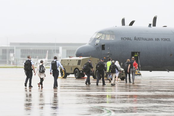 Australian Federal Police personnel board an RAAF C-130 Hercules  bound for the Solomon Islands at RAAF Fairbairn in Canberra in 2021.