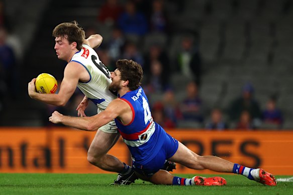George Wardlaw of the Kangaroos is challenged by Marcus Bontempelli of the Bulldogs.