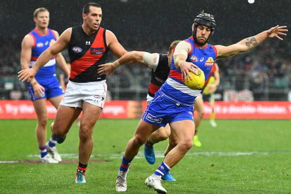 Caleb Daniel gets a kick away in the wet.