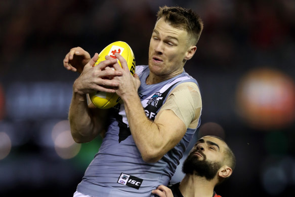 Robbie Gray of the Power marks in front of Adam Saad of the Bombers.