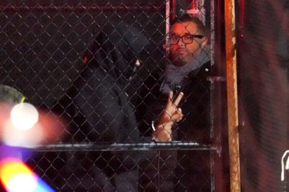 Ousted Venezuelan President Nicolás Maduro at New York’s Westside Heliport, wearing a hoodie and handcuffs, makes a peace sign.