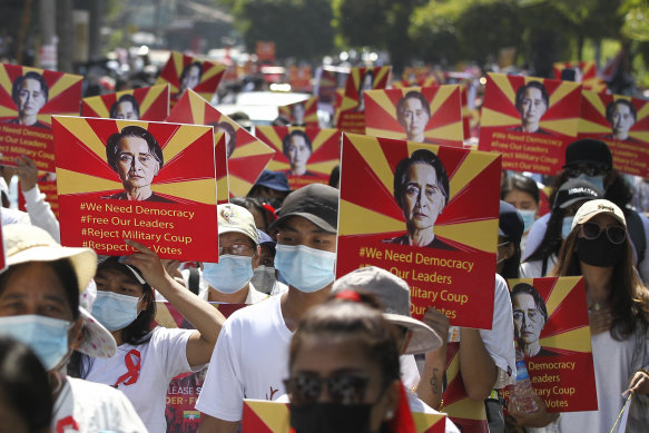 Anti-coup protesters held posters of deposed Myanmar leader Aung San Suu Kyi as they gathered outside the UN Information Office in Yangon on Sunday.