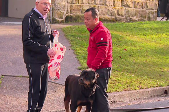 “Owen” Ouyang Chen (right) and his dog on Cliff Road in Northwood after one of his properties was set alight.
