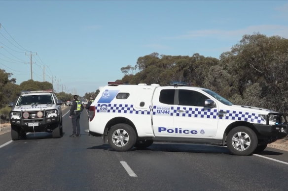 Two police vehicles guard the crash scene.