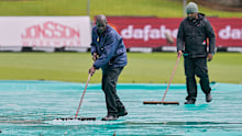Groundsmen remove water.