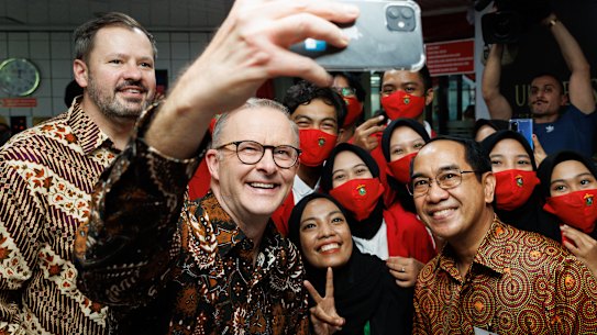 Industry and Science Minister Ed Husic and Prime Minister Anthony Albanese take a selfie with students at the Universitas Hasanuddin in Makassar, Indonesia.