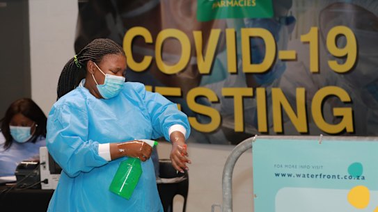 A healthcare worker sanitises her hands before conducting COVID-19 tests at a drive-through testing station in Cape Town, South Africa.