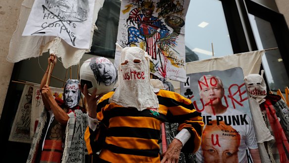 British Fashion designer Vivienne Westwood, centre, with her head covered, poses for photos during a protest to support Julian Assange outside the Central Criminal Court Old Bailey in London.