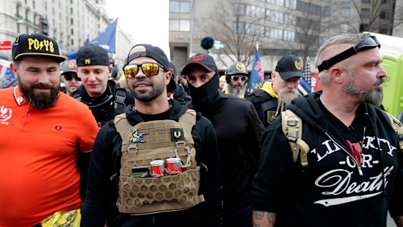 Supporters of President Donald Trump who are wearing attire associated with the Proud Boys watch during a rally at Freedom Plaza.