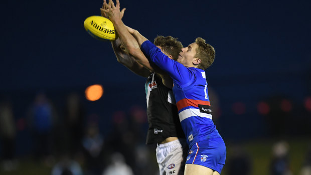 Dark and stormy: Port's Brad Ebert and Bulldog Lachie Hunter go up for a contest during a poorly-lit last quarter at Mars Stadium in Ballarat.