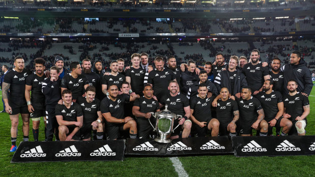 The All Blacks pose with the spoils of victory following their 36-0 humiliation of the Wallabies.