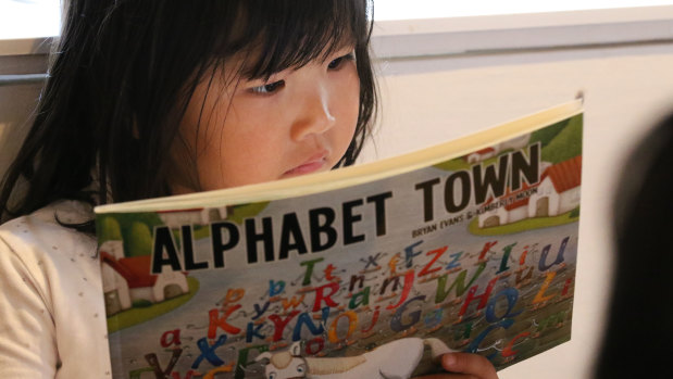 A young girl reading a book by Australian writers at Beijing's Happy Space library.
