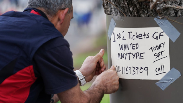 A fan searches for AFL Grand Final tickets outside the MCG on Saturday morning.