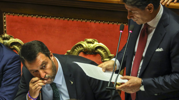 Matteo Salvini, left, kisses his rosary beads as Giuseppe Conte addresses the Senate.
