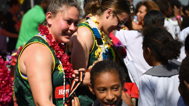 Cult hero: Rhiannon Revell-Blair (left) is mobbed by students as the Jillaroos visited Wardstrip Demonstration Primary School in Papua New Guinea.