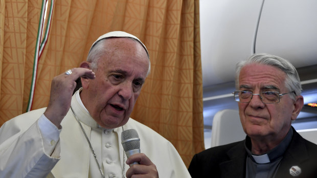 Pope Francis, flanked by Vatican spokesman Federico Lombardi, right, talks to journalists during a press conference he held on board the airplane on his way back to the Vatican in 2016.