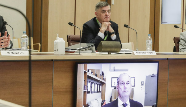 Department of Health secretary Brendan Murphy (seated) and Aged Care Minister Richard Colbeck (appearing via videoconference) at a Senate select committee hearing in Canberra this week.