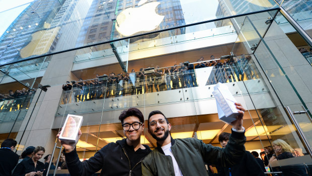 Sydney student Teddy Lee and Mazen Kourouche (right) hold up their prizes after being first in line for new iPhones.