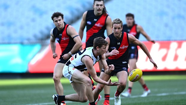 Will Hoskin-Elliott of the Magpies handballs.