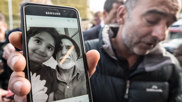 Yama Nabi, above, holds a photo of his father, Haji Daoud, who was killed in the attack.