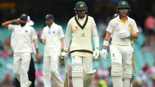 Reprieve: Usman Khawaja and Marcus Harris leave the field as the tea break is called early due to bad light.