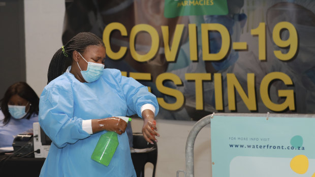 A healthcare worker sanitises her hands before conducting COVID-19 tests at a drive-through testing station in Cape Town, South Africa.