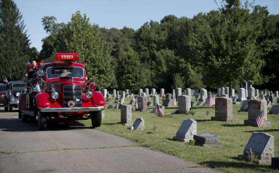 The coffin of Joe Heller is brought to the cemetery on the Essex Fire Department's historic truck in Essex, Connecticut.