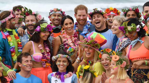 Britain's Prince Harry and Meghan, the Duchess of Sussex, pose at Bondi Beach with surfing community group, known as OneWave, who raise awareness for mental health and wellbeing.