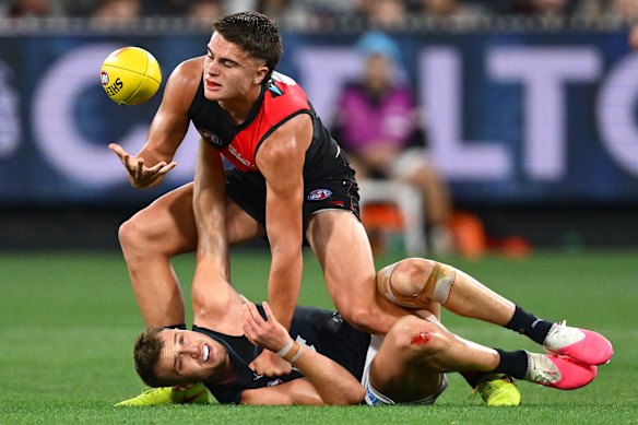 Patrick Cripps of the Blues is tackled by Sullivan Robey of the Bombers.