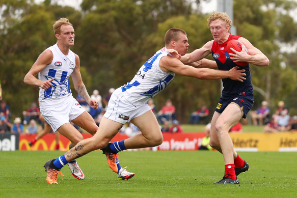 Demon midfielder Clayton Oliver is tackled by the Roos’ Cameron Zurhaar.