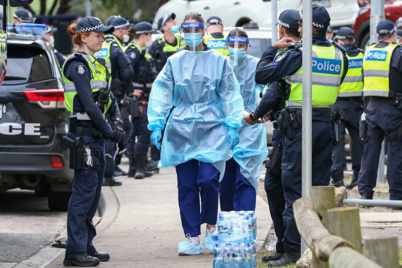 Police and health workers outside the Flemington public housing flats when they were locked down in early July.