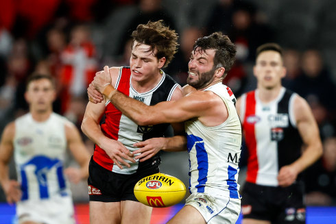 Saints player Mattaes Phillipou is tackled by Luke McDonald of North Melbourne in July 2023.